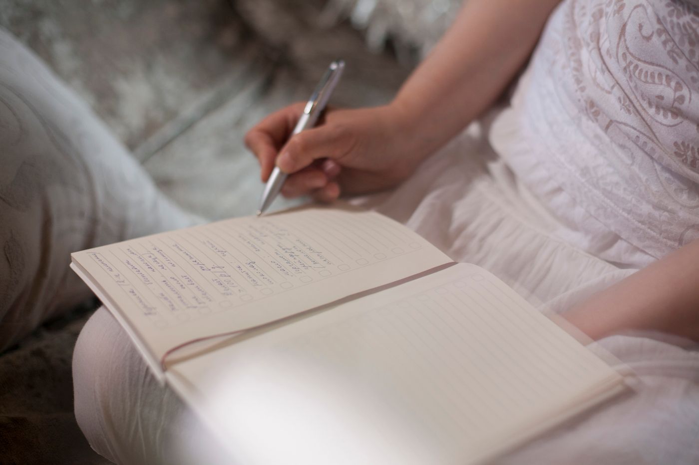 A person writing by hand in an open notebook, photographed by Sergey Torbik
