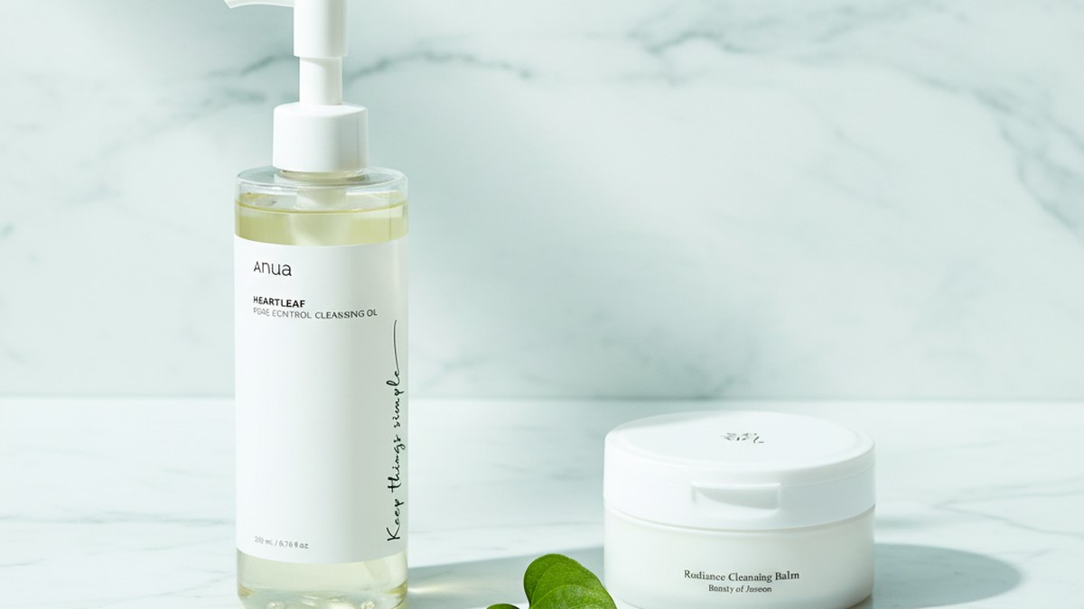 A close-up of cleansing oil being massaged into skin, showing the emulsification process